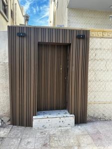 a wooden door with a bench in front of a building at Mangroves luxury suites in Al Madinah
