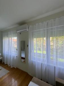 バニャ・ルカにあるStudio 33の白いカーテンと大きな窓が備わる客室です。