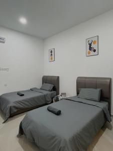 2 bedden in een witte kamer met: bij Elonna Homestay in Jerantut