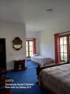 um quarto com 2 camas e um espelho na parede em Villa Como em Maskeliya