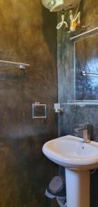 uma casa de banho com um lavatório branco e um espelho. em Villa Como em Maskeliya