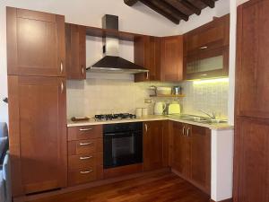 eine Küche mit Holzschränken und einem Herd mit Backofen in der Unterkunft Appartamento Pianzola in Orvieto + 15 Fotos