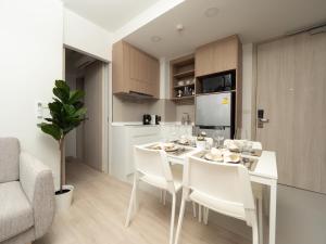 a kitchen and dining room with a white table and chairs at Excellent 2bd apartment with a patio in Phuket Town