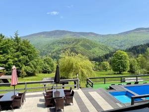 a patio with chairs and umbrellas and a swimming pool at Romanka in Żabnica