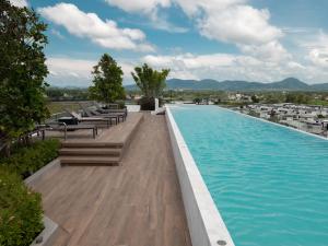 a large swimming pool with benches and chairs on a building at Excellent 2bd apartment with a patio in Phuket Town