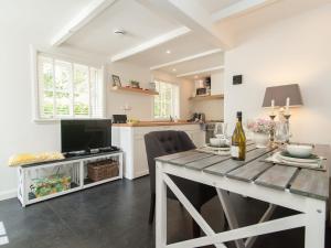 eine Küche mit einem Esstisch und einem TV in der Unterkunft Pleasing Holiday Home in Schoorl with Patio in Schoorl