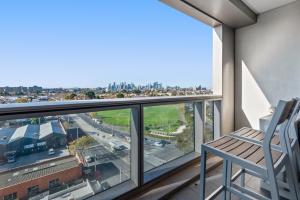 a balcony with a chair and a view of a street at FLEMINGTON - Melbourne City Views in Melbourne