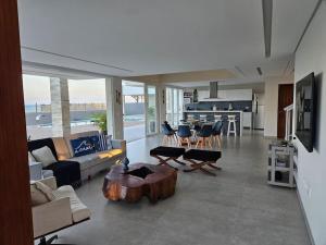 uma sala de estar com um sofá e uma mesa de centro em Beira mar com vista espetacular! Quinta da Barra! em Barra do Sirinhaém