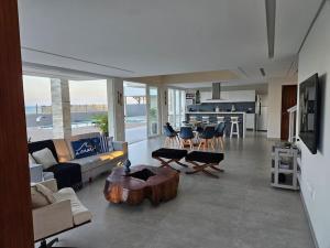 Μια τηλεόραση ή/και κέντρο ψυχαγωγίας στο Piscina aquecida, 5 suítes e pé na areia com vista espetacular!!