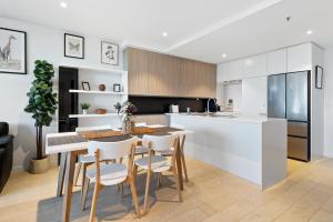a kitchen with a table and chairs in a room at FLEMINGTON - Melbourne City Views in Melbourne