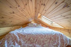 a large bed in a wooden room with a window at The Railway Weigh Office (Cliburn) in Penrith