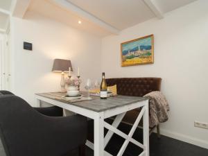 einen Tisch mit einer Flasche Wein und zwei Stühlen in der Unterkunft Pleasing Holiday Home in Schoorl with Patio in Schoorl