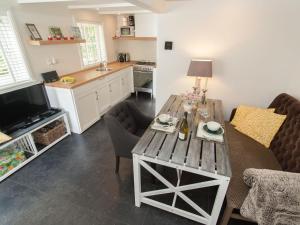 eine Küche und ein Wohnzimmer mit einem Holztisch in der Unterkunft Pleasing Holiday Home in Schoorl with Patio in Schoorl