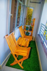 due sedie in legno sedute su un portico con erba di Othaya Hideout a Othaya