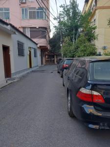 uma fila de carros estacionados ao lado de uma rua em Center Cozy Nest em Tirana