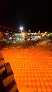 un aparcamiento iluminado por la noche con en Thenoblejewel, en Al Laqīţah