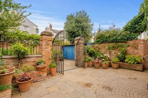 un jardín con una puerta y un montón de macetas en orwell villa elegant period 5 bed close to town sleeps 15, en Cheltenham