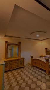 1 dormitorio con 1 cama grande y espejo en Thenoblejewel, en Al Laqīţah