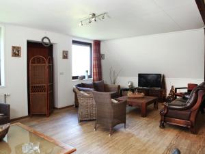 a living room with a couch and chairs and a tv at Welcoming Farmhouse in Eede near centre in Eede