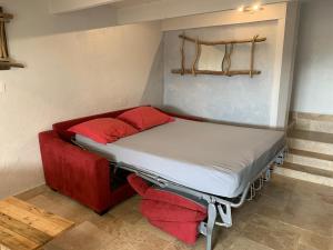 a bed in a room with red pillows on it at Appartement FredMart in Mougins