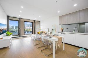 a kitchen with a white table and some chairs at Aircabin - Zetland - Lovely - 2 Beds Apt Free Park in Sydney