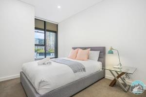 a bedroom with a bed and a glass table at Aircabin - Zetland - Lovely - 2 Beds Apt Free Park in Sydney
