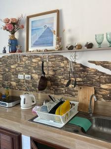 a kitchen counter with a sink and a stone wall at Studio at the Beach in Ban Ao Makham