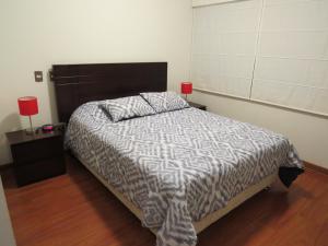 a bedroom with a bed and a red lamp on a table at Spacious Apartment in Miraflores in Lima
