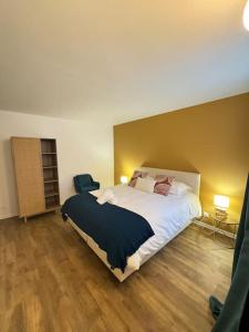 une chambre avec un grand lit blanc et du parquet dans l'établissement Les pensées D'Anne & Marie 2/4 Personnes, à Eguisheim