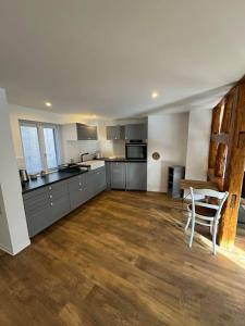 a large kitchen with stainless steel appliances and wooden floors at Les pensées D'Anne & Marie 2/4 Personnes in Eguisheim