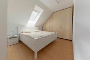 ein weißes Schlafzimmer mit einem Bett und einem Fenster in der Unterkunft Apartment Tati in Dol pri Ljubljani