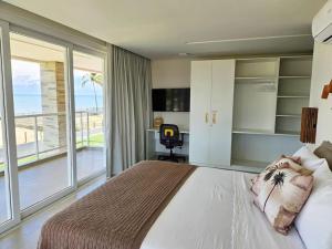 a bedroom with a large bed and a balcony at Beira mar com vista espetacular! Quinta da Barra! in Barra do Sirinhaém