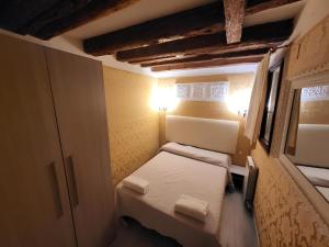 Kleines Zimmer mit einem Bett und einem Fenster in der Unterkunft Otto House Apartment in Venedig