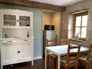 a kitchen with a white table and a white refrigerator at La Cour in Villefagnan