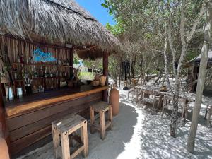 a bar with benches and a straw hut at Hotel Casa Punta Coco & Beach Club - Adults Only in Holbox Island