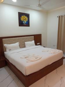 ein Schlafzimmer mit einem großen Bett mit weißer Bettwäsche in der Unterkunft The Amur Falcon Inn & Resorts in Rāja Sānsi