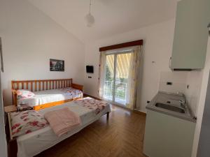 1 dormitorio pequeño con 2 camas y lavamanos en Garden Villa Sunny, en Tale