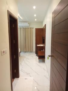 Zimmer mit einem Bad mit einem Waschbecken und einer Tür in der Unterkunft The Amur Falcon Inn & Resorts in Rāja Sānsi