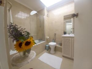 a bathroom with a toilet and a vase with a flower at Casa Delfina in Simonʼs Town