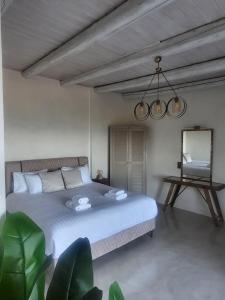 a bedroom with a large bed and a mirror at VillaAurora-mani in Areopoli