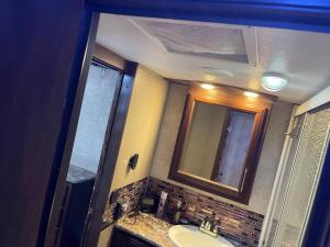 a bathroom with a sink and a mirror at Entire 1bedroom RV Camper in Fort Pierce