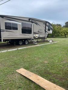 皮爾斯堡的住宿－Entire 1bedroom RV Camper，木板停泊在田野中的 ⁇ 