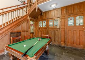 a pool table in a room with wood paneling at Otter Pool Barn in West Down