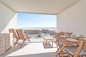 a balcony with a table and chairs and a large window at Global Properties, Apartamento con vistas al mar, Canet d'en Berenguer in Canet de Berenguer