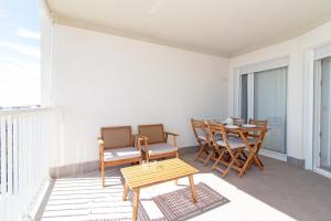 a balcony with a wooden table and chairs on a balcony at Global Properties, Apartamento con vistas al mar, Canet d'en Berenguer in Canet de Berenguer