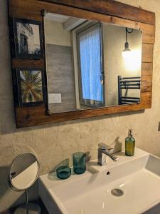 ein Waschbecken mit Spiegel und Spiegel in der Unterkunft Mansarda Morlana in Alzano Lombardo