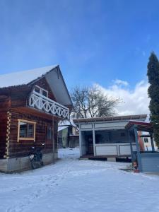 dom ze śniegiem na ziemi przed nim w obiekcie Hutsul hygge house w mieście Velykyi Khodak