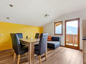 ホラースバッハ・イム・ピンツガウにあるSunlit Apartment near Ski Area in Hollersbach im Pinzgauのダイニングルーム(テーブル、椅子付)