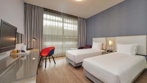 um quarto de hotel com duas camas e uma televisão em Holiday Inn Express Taichung Park, an IHG Hotel em Taichung