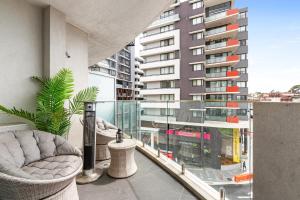 a balcony with two chairs and a large building at Elegant 1-Bed by Riverside Park & Amenities in Sydney